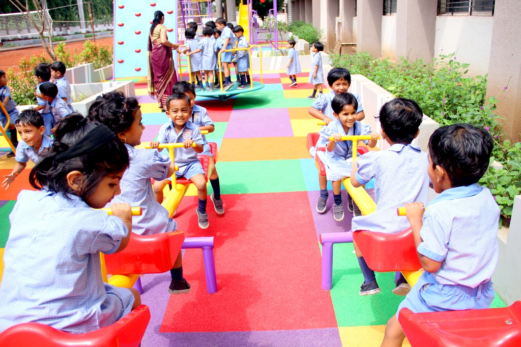 Little Kids of Pre-Primary playing on a Seesaw at School Playground.
